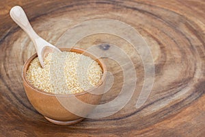 brown sugar in wooden bowl with scoop isolated on wood