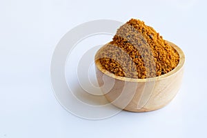 Brown sugar in wooden bowl on white