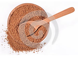 Brown sugar in a wooden bowl on a white