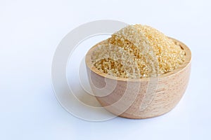 Brown sugar in wooden bowl on white