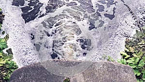 Brown swamp water flows down the pipe