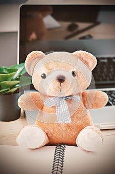 Brown teddy bear with blue ribbon bow