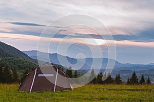 Brown tent. Quick installation system. Summer day. Mountains and forest, travel and tourism concept. Camping. Copy space