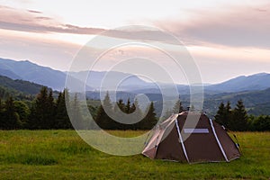 Brown tent. Quick installation system. Summer day. Mountains and forest, travel and tourism concept. Camping. Copy space