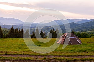 Brown tent. Quick installation system. Summer day. Mountains and forest, travel and tourism concept. Camping. Copy space