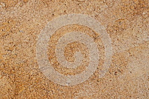 Brown texture of a concrete wall. Closeup of a brown yellow texture of a concrete wall with a hilly uneven surface. Abstract