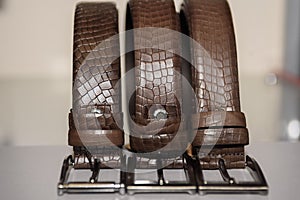 Brown textured leather belts in brown on the counter in the store