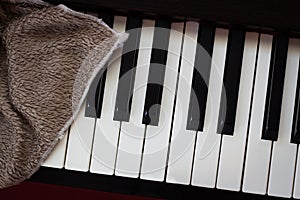 Brown towel on piano. Classical music instrument. Concept of cleaning