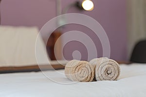 brown towels rolls on bed sheet in the hotel.