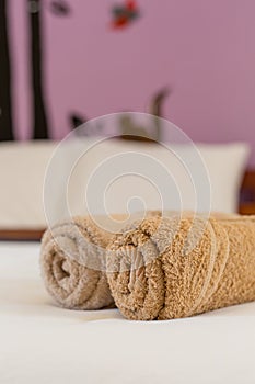 brown towels rolls on bed sheet in the hotel