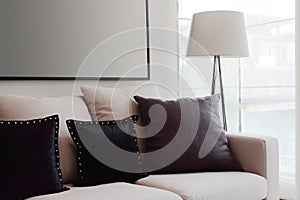 Brown tweed sofa with grey pillows and lamp