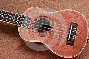 Brown Ukulele Lay on Old Brown Wood Table