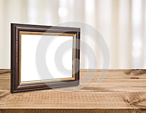 Brown vintage picture frame on wood over abstract curtain background