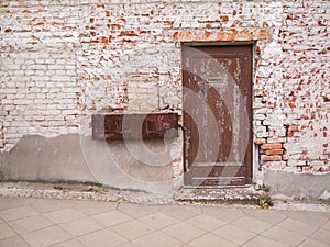 Brown weathered door in weathered brick wall