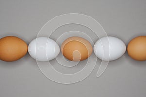 Brown and white chicken eggs lined up in a row