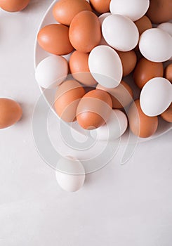 Brown and white eggs on a white plate on a white background. Eggs. Easter photo concept.