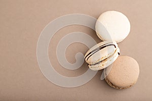 Brown and white macaroons on beige pastel background. top view, copy space