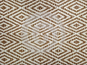 Brown and white woven textile featuring a repeating diamond pattern.