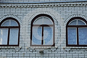 brown windows on a gray brick wall of a house