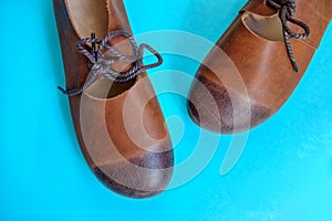 Brown women`s leather shoes on blue background