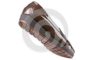 Brown women`s patent leather low-soled shoes with a tread, as if walking, on a white background