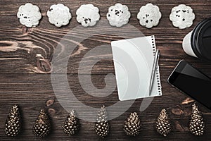 Brown wood background. Gold cones and sweet biscuits arranged diametrically opposed.