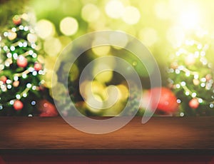 Brown Wood table top with abstract blur christmas tree background with bokeh light,Holiday backdrop,Mock up for display or