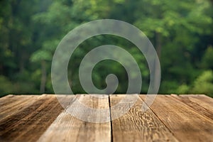 Brown wood table top on a green blur abstract background