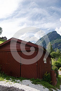 brown wooden barn and beautiful mountains behind Aurlandsfjord Flam