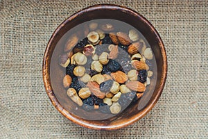 Brown wooden bowl with nuts. View on top