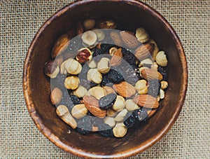 Brown wooden bowl with nuts. View on top