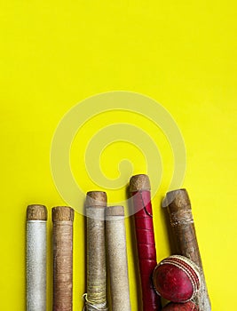 Brown wooden cricket handles which are bound by cotton yarn and artificial leather on yellow background