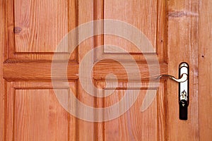 Brown wooden door with handle and key