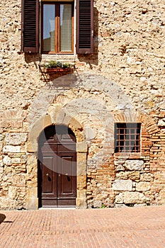 Brown wooden doors in an old stone wall