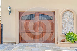 Brown wooden garage door with glass panes in Huntington Beach California