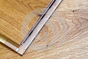 Brown wooden parquet floor planks installation , close up. Carpentry concept.