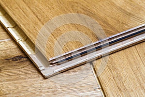 Brown wooden parquet floor planks installation , close up. Carpentry concept.