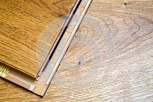 Brown wooden parquet floor planks installation , close up. Carpentry concept.