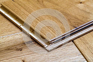 Brown wooden parquet floor planks installation , close up. Carpentry concept.