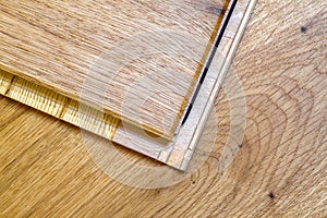 Brown wooden parquet floor planks installation , close up. Carpentry concept.