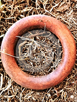 Brown wooden ring with dry grass in background