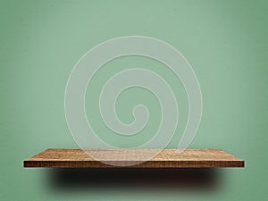 Brown wooden shelf for product display on green background