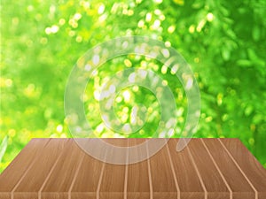 Brown wooden table on blurred greenery nature background, Natural template Foliage green leaves texture backlight bokeh sunshine