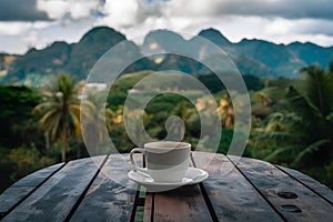 Brown wooden table with blurred tropical mountain landscape