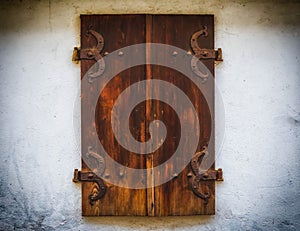 Brown wooden window shutters with old stone wall background old wood window style.