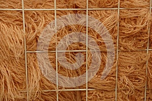 Brown woolen fabric behind a metal lattice