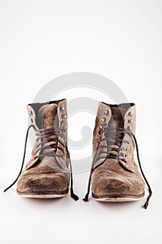 Brown worn vintage boots with untied laces in studio