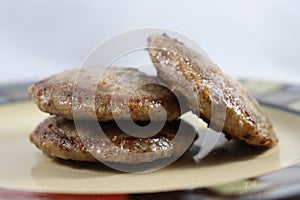 Browned sausage patties stacked on saucer plate