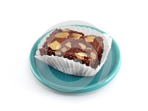 brownie cake in square pleat paper cup on green ceramic saucer