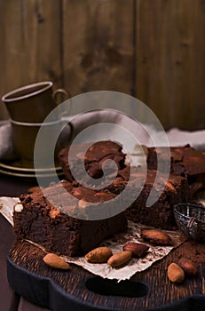 Brownie, Chocolate cakes with almonds on a wooden board, sprinkled with cocoa. Served homemade cakes. Top view. Free